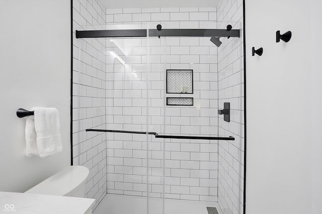 bathroom featuring toilet and an enclosed shower