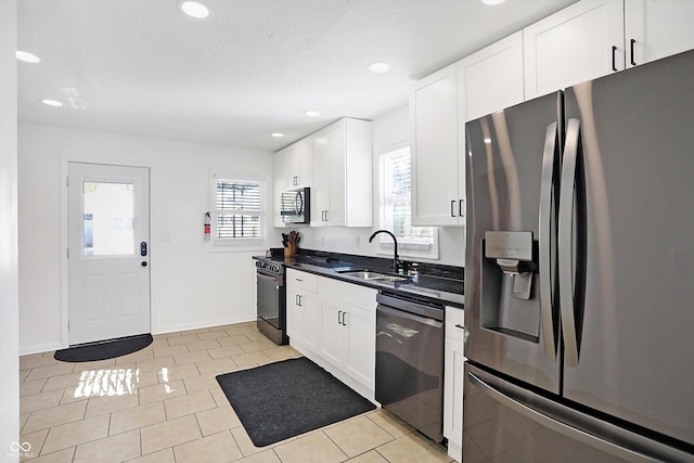 kitchen with a healthy amount of sunlight, stainless steel appliances, white cabinetry, and sink