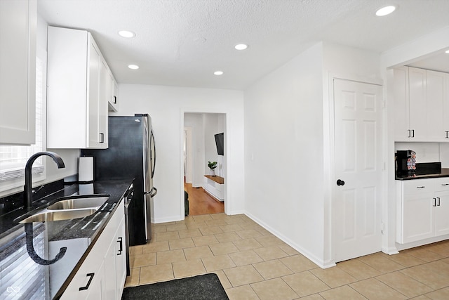 kitchen featuring white cabinetry, light tile patterned flooring, and sink