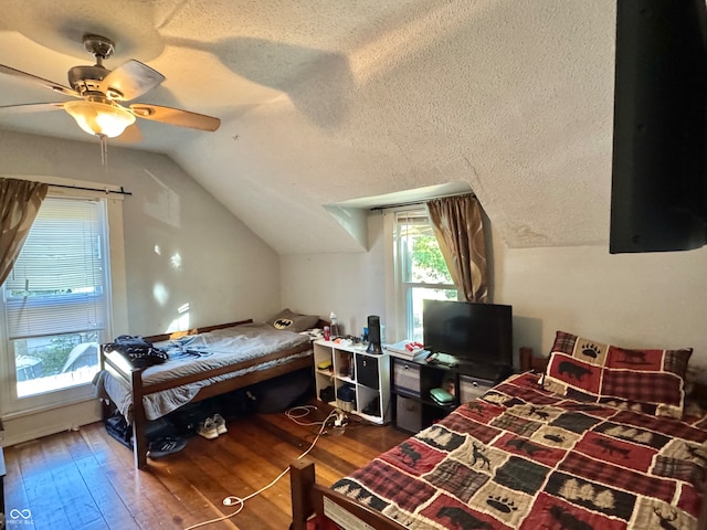 bedroom featuring a textured ceiling, ceiling fan, wood-type flooring, and vaulted ceiling