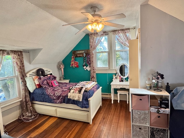 bedroom with lofted ceiling, a textured ceiling, hardwood / wood-style flooring, and ceiling fan