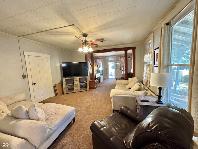 carpeted living room with ornamental molding and ceiling fan