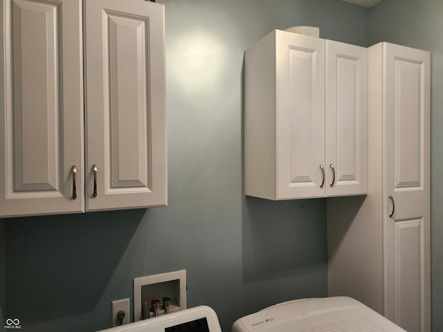 laundry room featuring washer / clothes dryer and cabinets