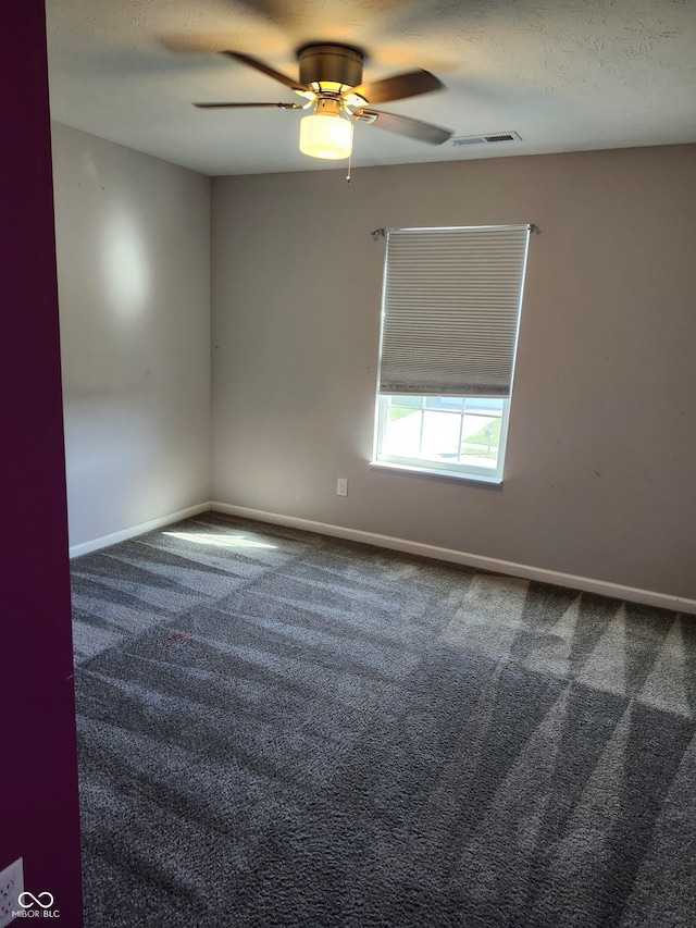 empty room featuring a textured ceiling, carpet, and ceiling fan