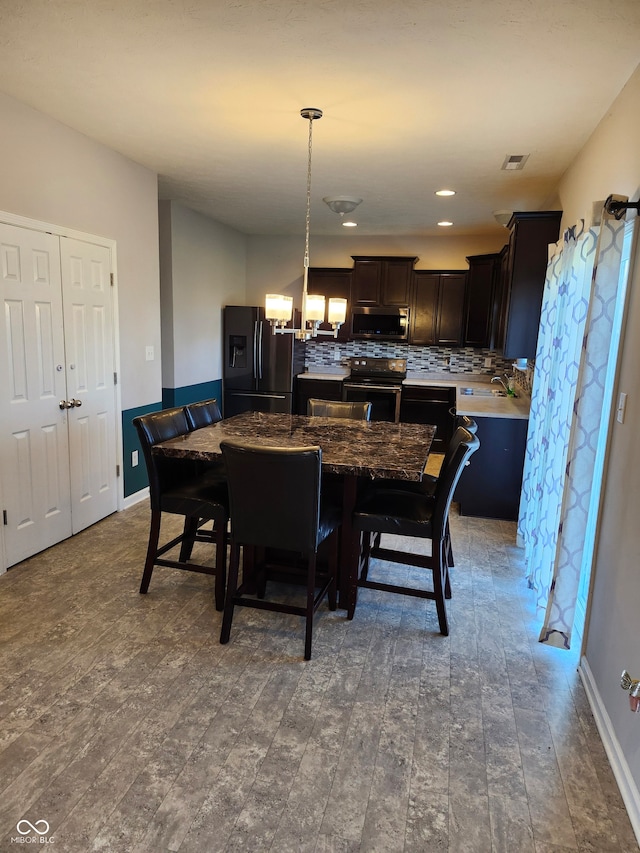 dining space with a notable chandelier and wood-type flooring