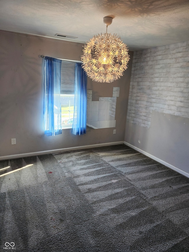 carpeted empty room featuring a textured ceiling