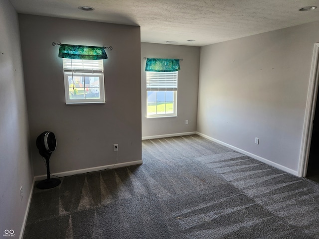 carpeted empty room with a textured ceiling