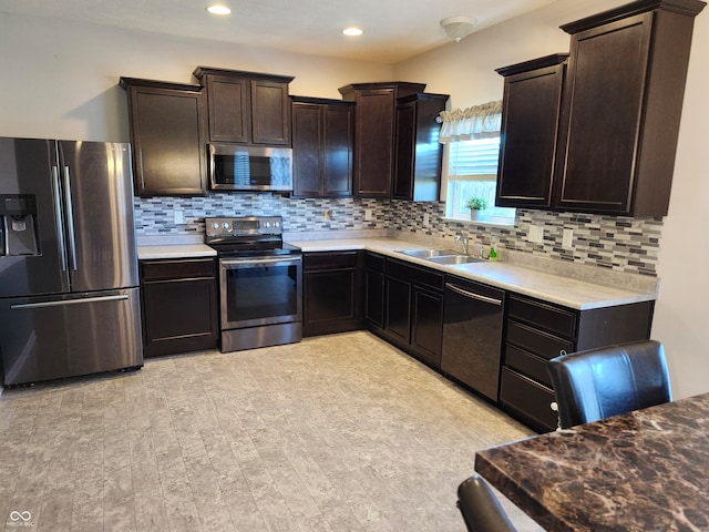 kitchen featuring appliances with stainless steel finishes, decorative backsplash, sink, and light hardwood / wood-style floors