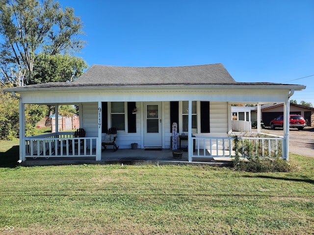 view of front of home with a porch, a front lawn, and a carport