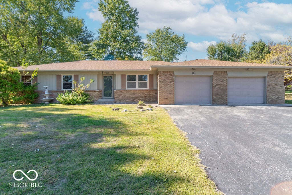 single story home featuring a garage and a front lawn