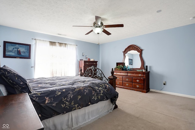 bedroom with ceiling fan, light carpet, and a textured ceiling