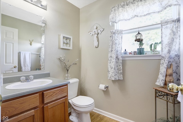 bathroom with vanity, hardwood / wood-style floors, and toilet