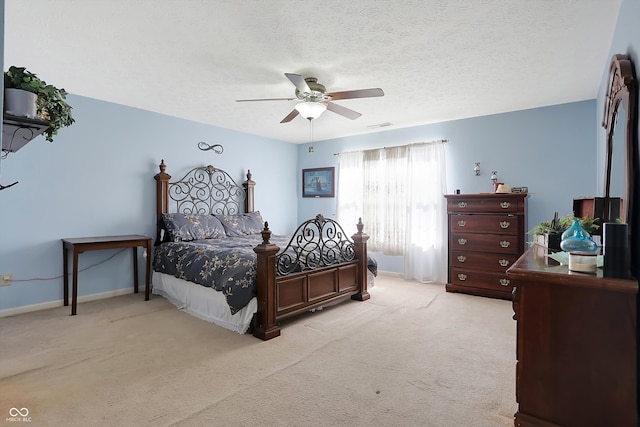 bedroom with light carpet, ceiling fan, and a textured ceiling