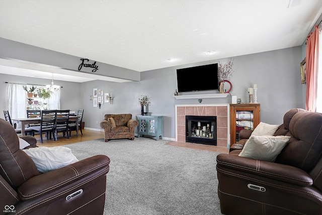 carpeted living room featuring a tiled fireplace