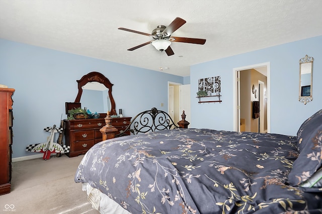 carpeted bedroom featuring ceiling fan and a textured ceiling