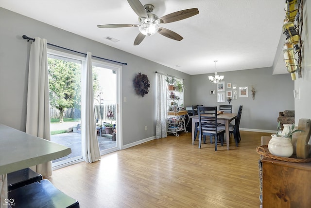 dining area featuring ceiling fan with notable chandelier and light hardwood / wood-style floors