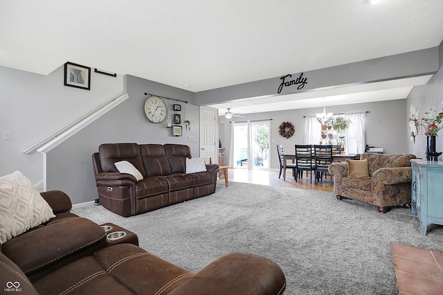 living room with carpet flooring and ceiling fan with notable chandelier