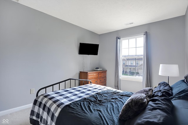 bedroom with a textured ceiling and carpet flooring