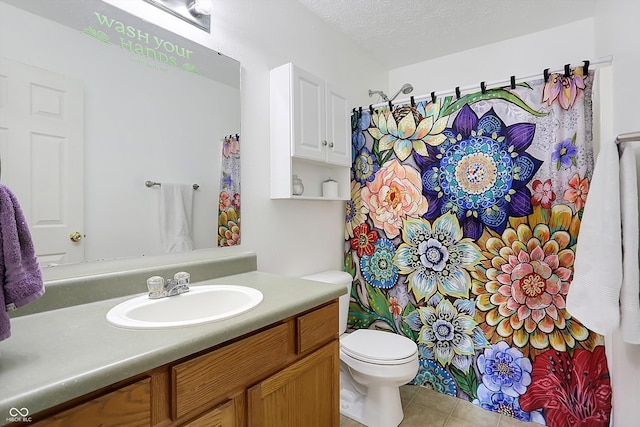 bathroom with vanity, tile patterned floors, a textured ceiling, and toilet