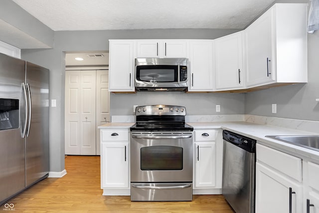 kitchen featuring white cabinetry, appliances with stainless steel finishes, and light hardwood / wood-style floors