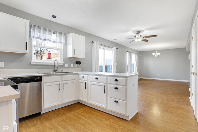 kitchen featuring sink, white cabinets, hanging light fixtures, stainless steel dishwasher, and kitchen peninsula