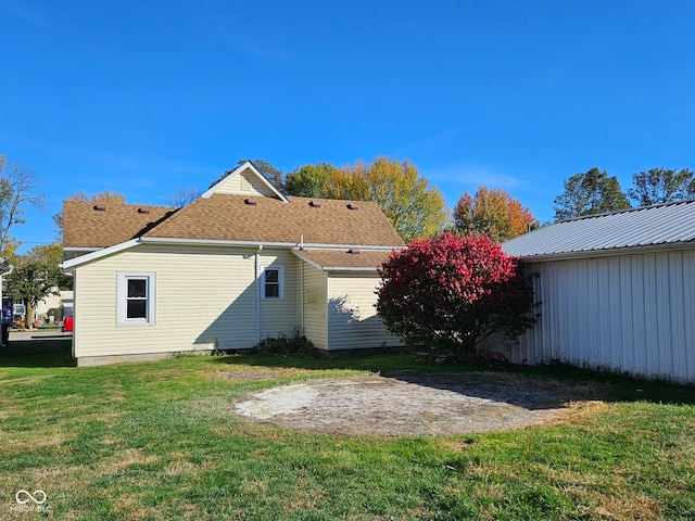 rear view of property featuring a lawn