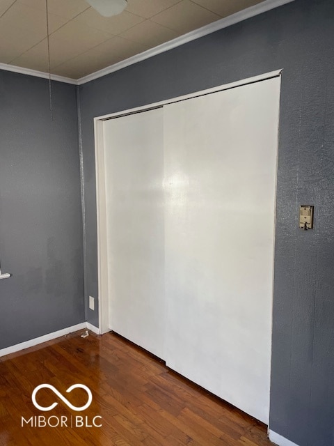 spare room with hardwood / wood-style flooring and crown molding