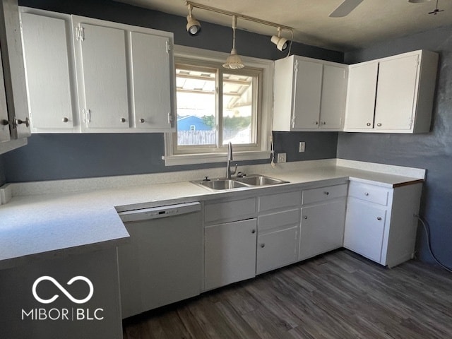 kitchen with sink, white dishwasher, dark hardwood / wood-style floors, hanging light fixtures, and white cabinets