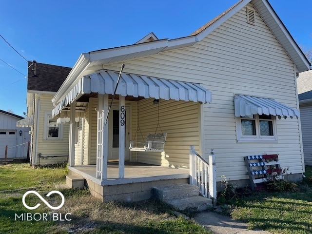 rear view of property with a lawn and covered porch