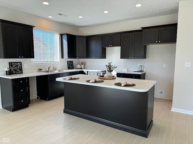 kitchen featuring light hardwood / wood-style floors, a center island, and sink