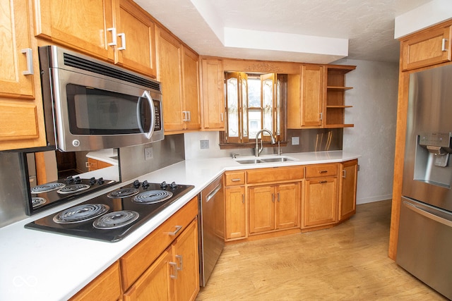 kitchen featuring light hardwood / wood-style flooring, stainless steel appliances, a textured ceiling, and sink