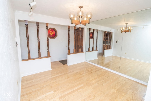 spare room with crown molding, hardwood / wood-style flooring, and a chandelier