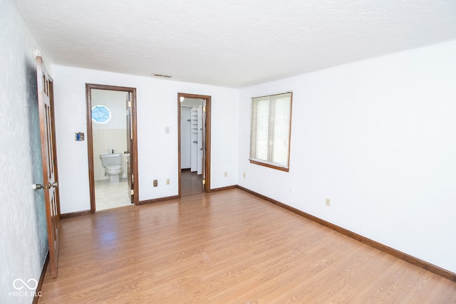 empty room featuring light hardwood / wood-style flooring and a textured ceiling