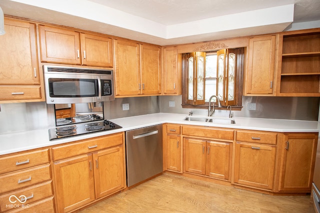 kitchen featuring stainless steel appliances, sink, and light wood-type flooring