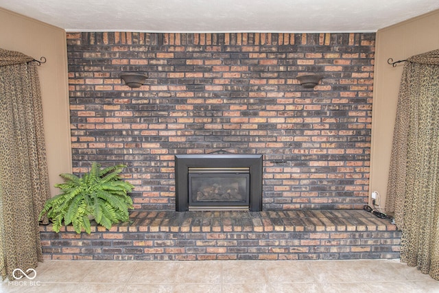 details with a textured ceiling, tile patterned floors, and a brick fireplace