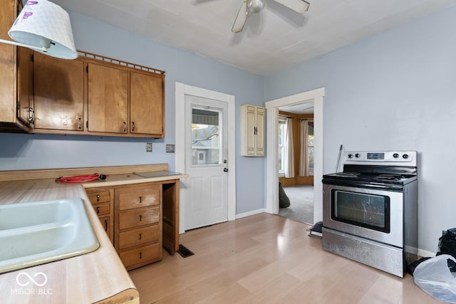 917 S 15th St, New Castle, IN 47362 - kitchen featuring a sink, ceiling fan, light countertops, electric stove, and brown cabinetry