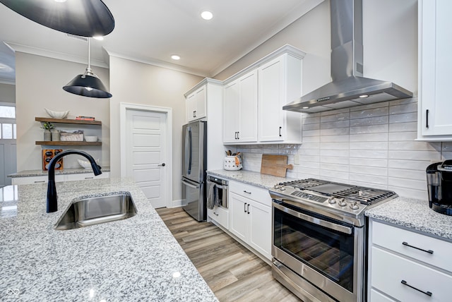 kitchen featuring sink, wall chimney exhaust hood, light hardwood / wood-style flooring, white cabinets, and appliances with stainless steel finishes