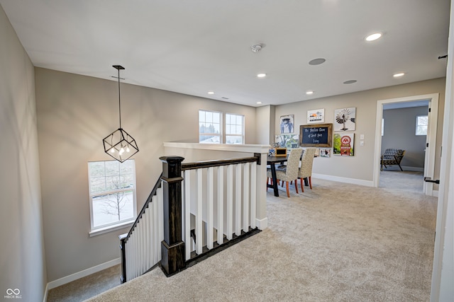 hallway with carpet flooring and an inviting chandelier