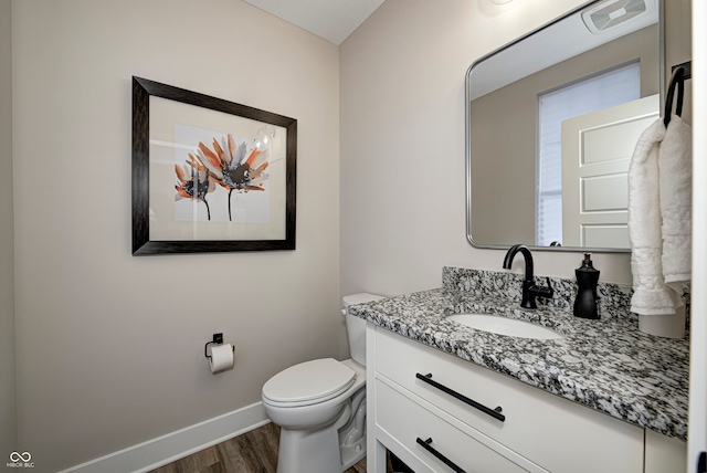 bathroom with vanity, hardwood / wood-style flooring, and toilet