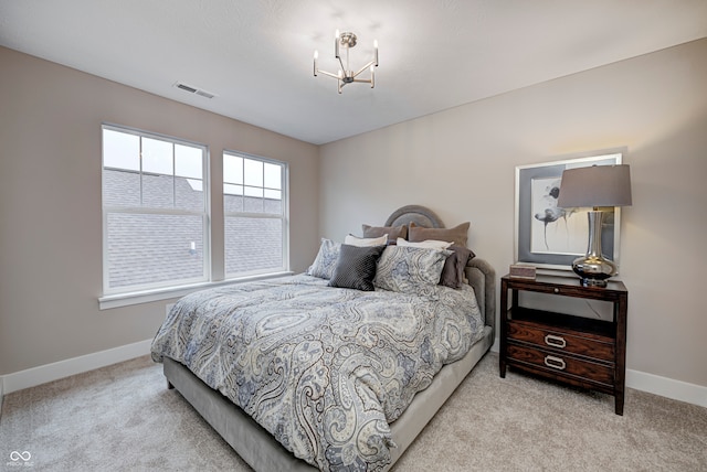 bedroom with light colored carpet and a notable chandelier