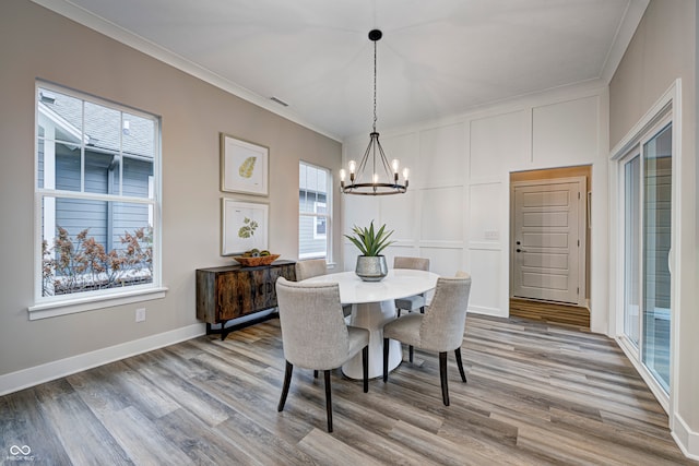 dining space featuring hardwood / wood-style floors, a wealth of natural light, and crown molding