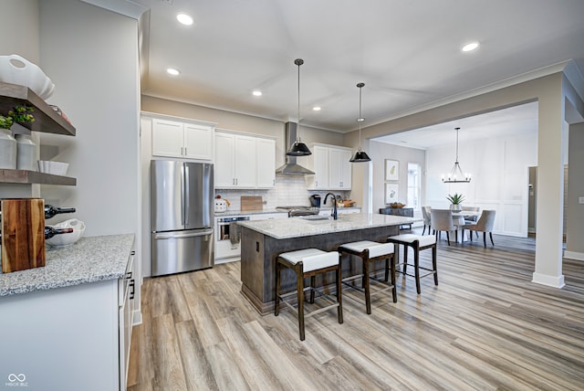 kitchen featuring light hardwood / wood-style floors, light stone countertops, white cabinetry, and appliances with stainless steel finishes