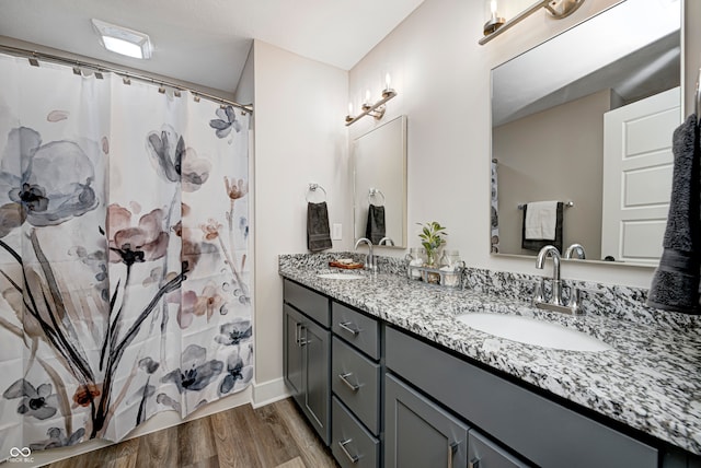 bathroom with hardwood / wood-style floors, vanity, and walk in shower