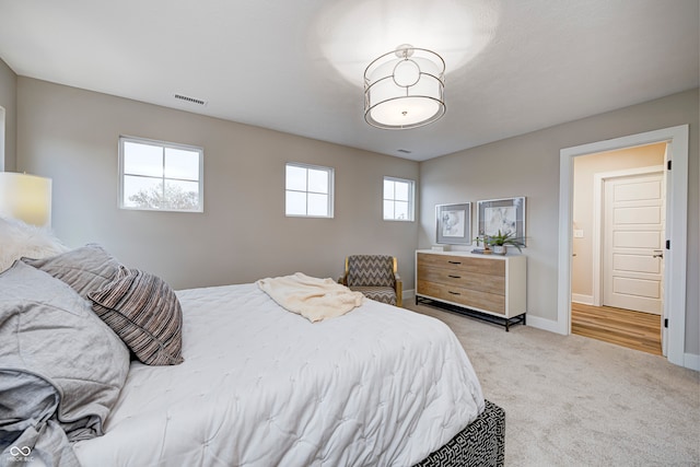 bedroom featuring light carpet and multiple windows