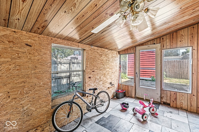 unfurnished sunroom with lofted ceiling, ceiling fan, wooden ceiling, and a wealth of natural light