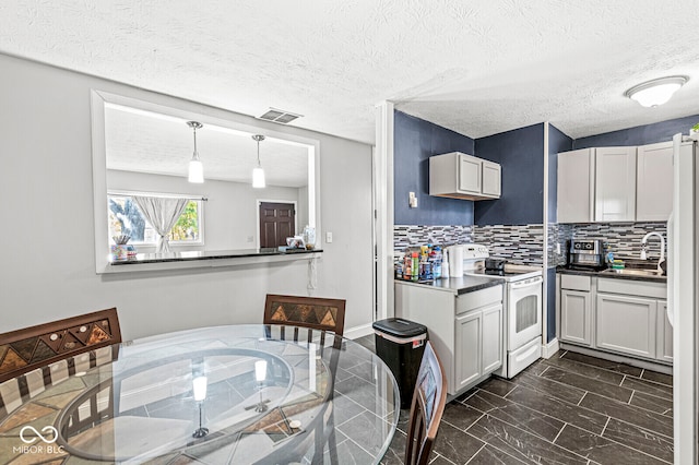 kitchen featuring tasteful backsplash, sink, electric stove, a textured ceiling, and pendant lighting