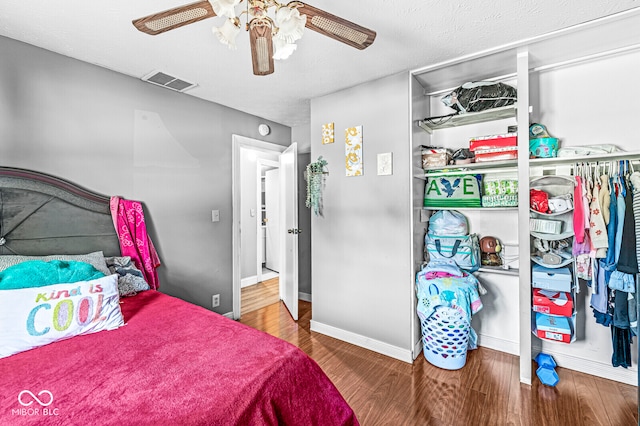 bedroom featuring a textured ceiling, wood-type flooring, and ceiling fan