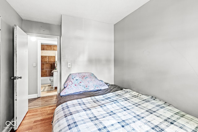 bedroom featuring a textured ceiling and light hardwood / wood-style flooring