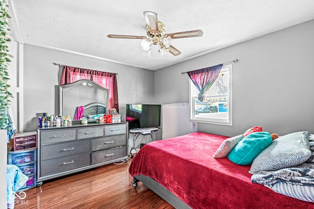 bedroom featuring a textured ceiling, wood-type flooring, and ceiling fan