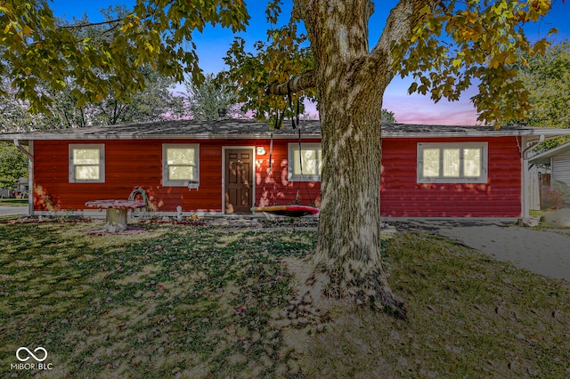 ranch-style home with a yard